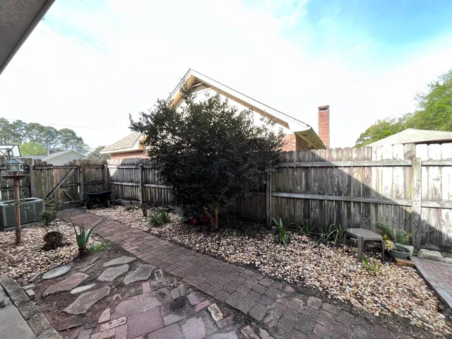 a backyard of a house with chairs and wooden fence