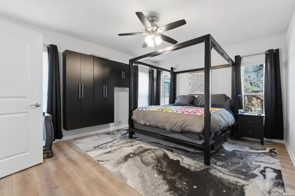 a bedroom with a bed mirror and a large window