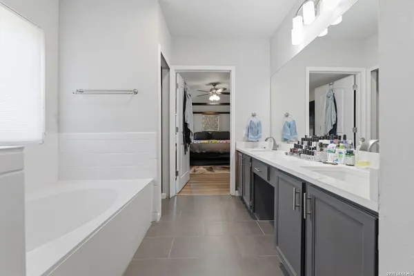 a en suite bathroom with a double vanity sink and a bathtub