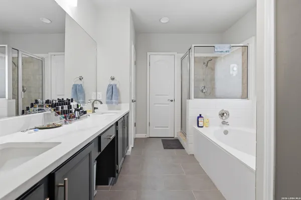 a bathroom with a tub a sink and mirror