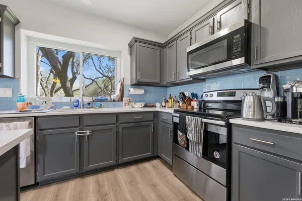 a kitchen with stainless steel appliances granite countertop a stove a sink and a microwave