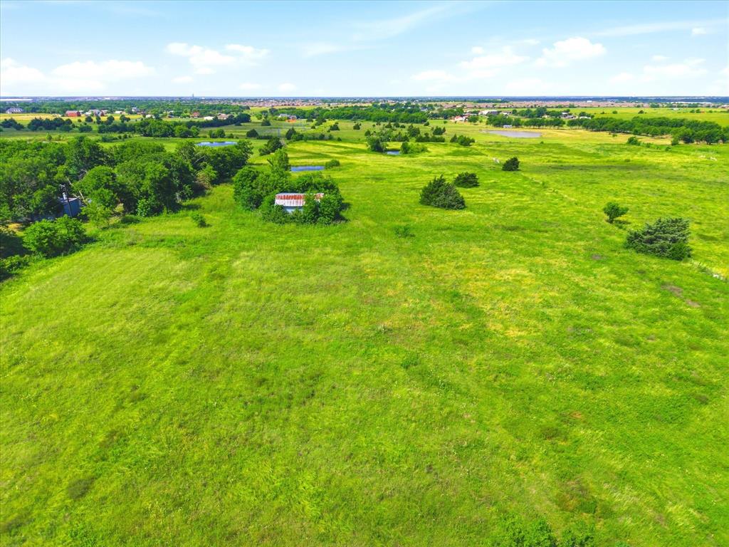 11749 Windy Lane Forney, TX 75126 - Photo 5 of 8 Expansive green acreage featuring scattered trees and a distant building