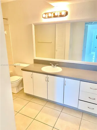 a bathroom with a sink a toilet and a mirror