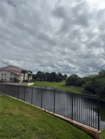 a view of a green field with wooden fence