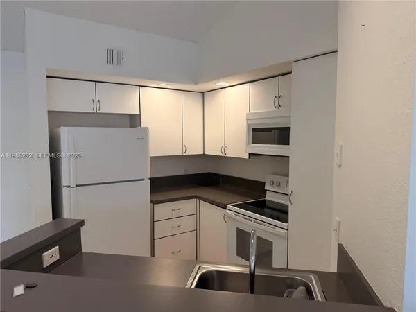 a kitchen with a refrigerator and a stove top oven