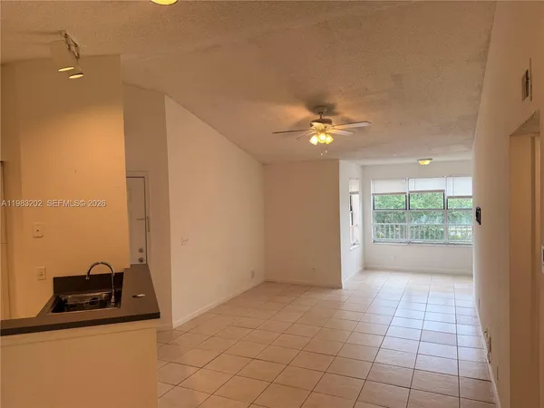 a view of a room with a ceiling fan and window