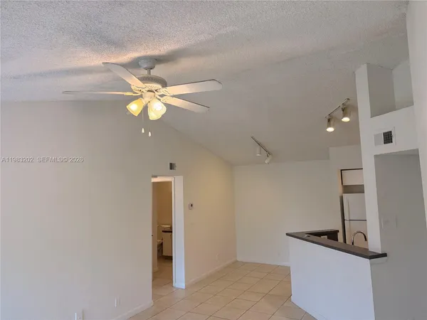 a view of a kitchen with a sink ceiling fan and refrigerator
