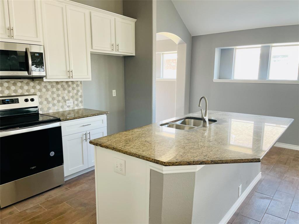 548 Kerry Street Crowley, TX 76036 - Photo 6 of 35 a kitchen with stainless steel appliances granite countertop a sink stove and microwave