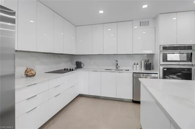 a kitchen with granite countertop white cabinets and white appliances