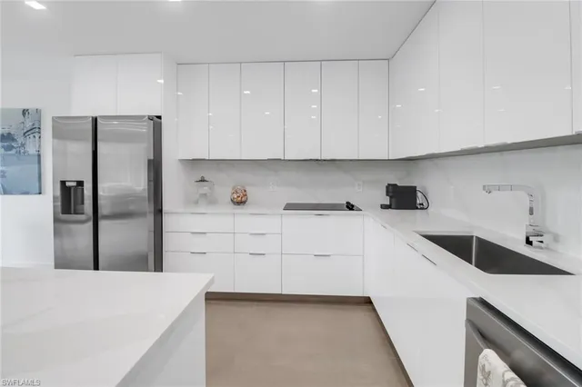 a kitchen with white cabinets and refrigerator