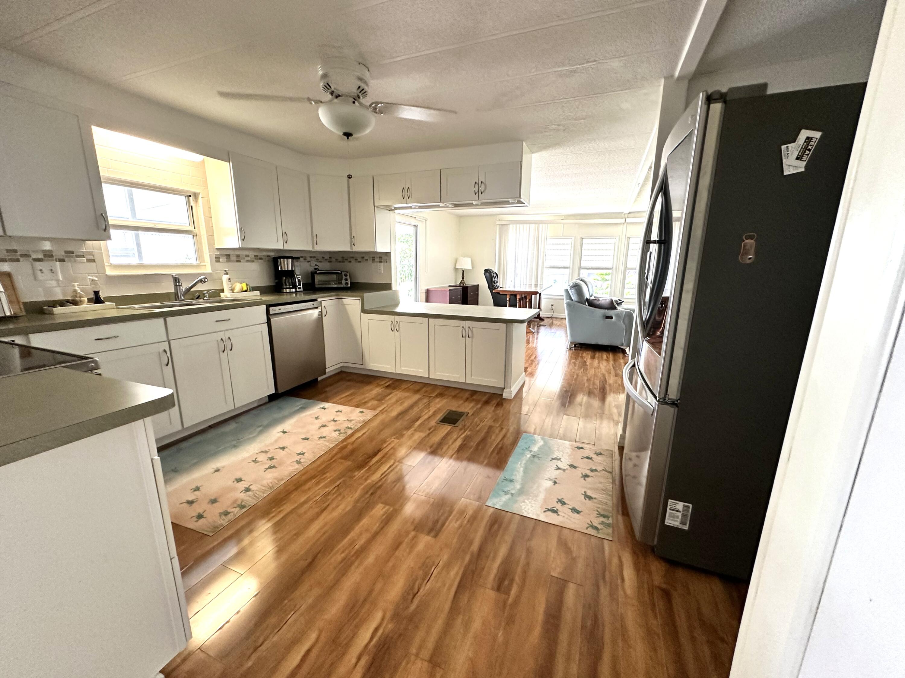 702 North Silver Circle Key Largo, FL 33037 - Photo 8 of 26 a open kitchen with stainless steel appliances granite countertop a refrigerator a sink dishwasher a stove and white countertops with wooden floor