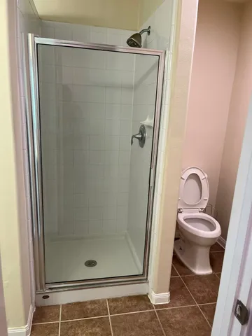 an empty room with wooden floor chandelier fan and closet area