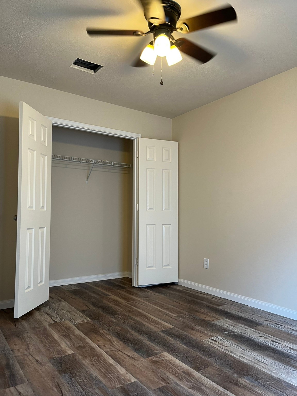 21650 Falvel Sunset Court Spring, TX 77388 - Photo 25 of 39 an empty room with wooden floor chandelier fan and closet area