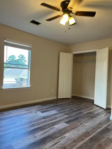 a view of an empty room and chandelier fan