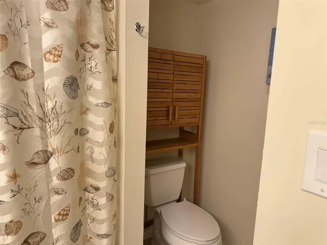 a white toilet sitting next to a shower curtain