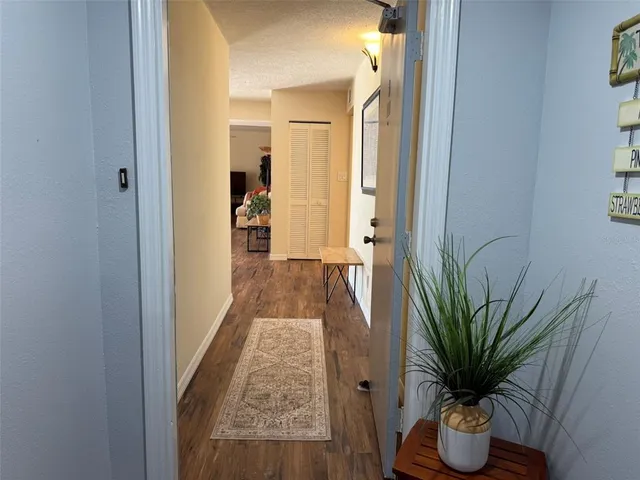a view of a hallway with wooden floor and a mirror