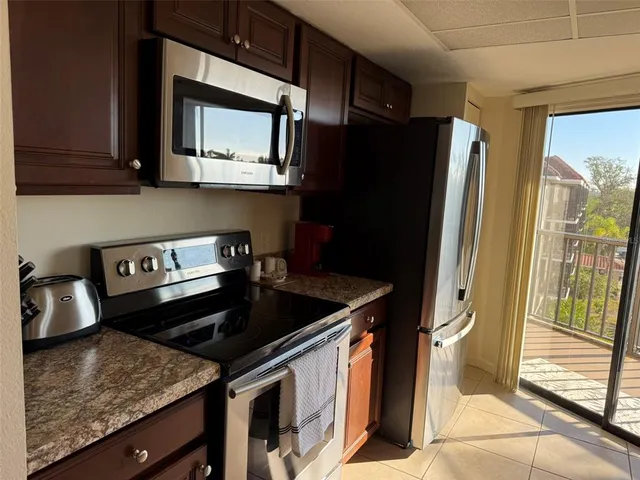 a kitchen with stainless steel appliances granite countertop a refrigerator and a stove