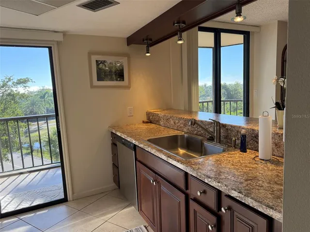 a bathroom with a granite countertop sink and a large mirror