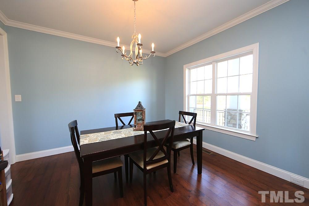 861 Bethlehem Church Road Youngsville, NC 27596 - Photo 2 of 25 a view of a dining room with furniture a chandelier and wooden floor