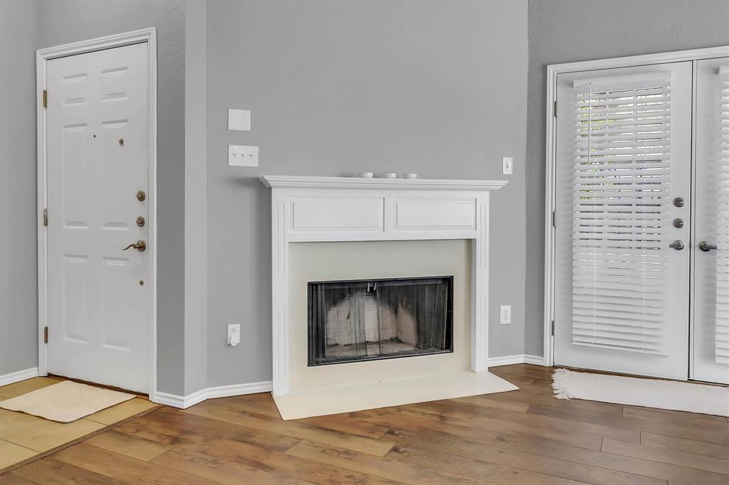 14333 Preston Road, Unit 2103 Dallas, TX 75254 - Photo 10 of 19 a view of an empty room with wooden floor and a fireplace