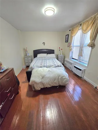 a bedroom with a bed and flat tv screen on the dresser