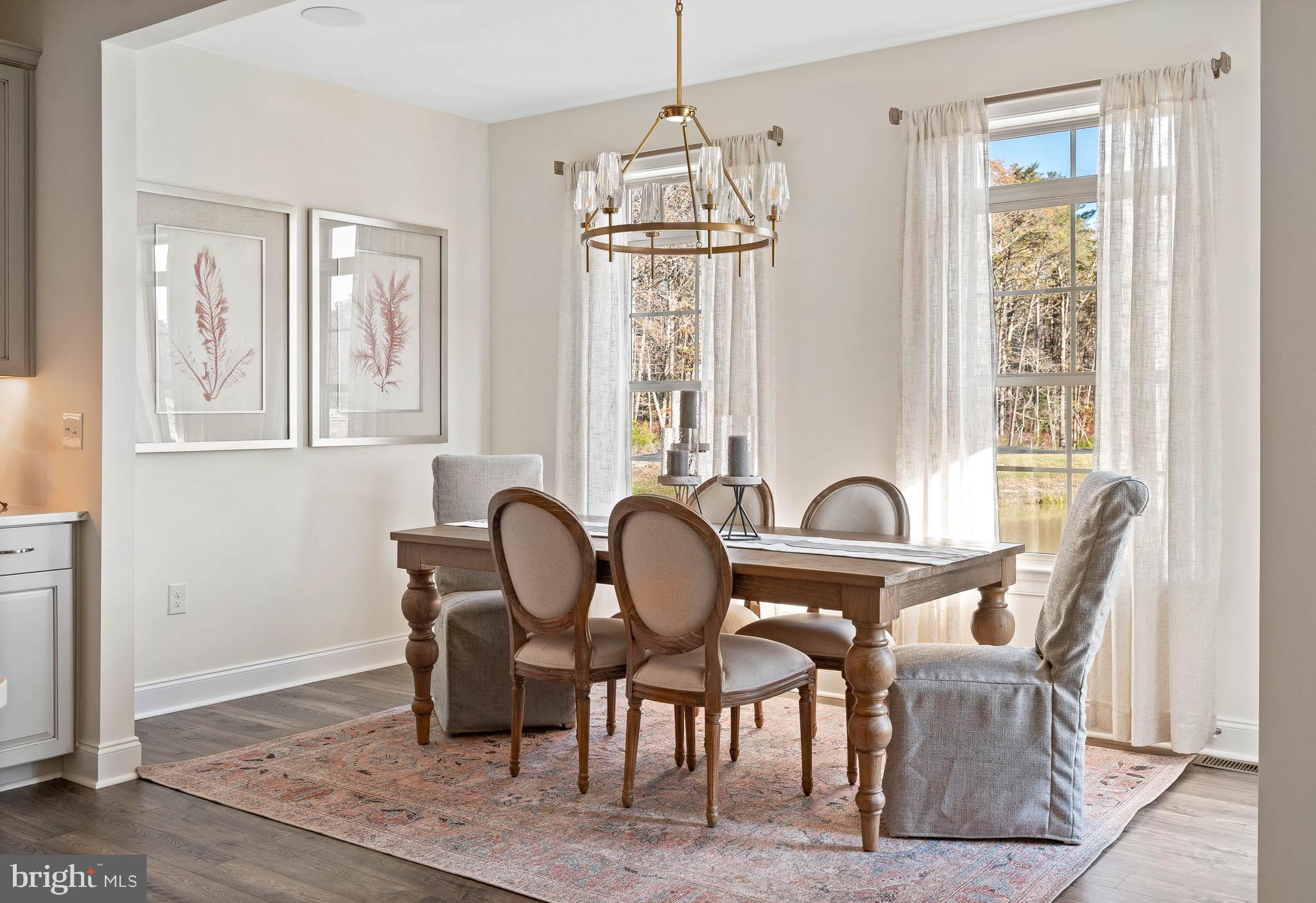 22544 Hummingbird Road Ellendale, DE 19941 - Photo 12 of 32 a dining room with furniture a chandelier and wooden floor