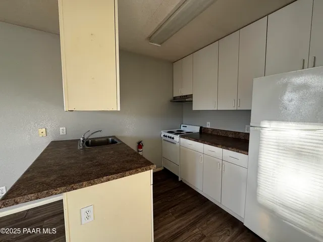 a kitchen with granite countertop a sink and a stove top oven