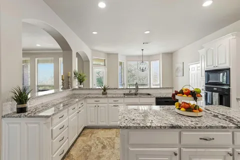 a kitchen with sink a window and cabinets