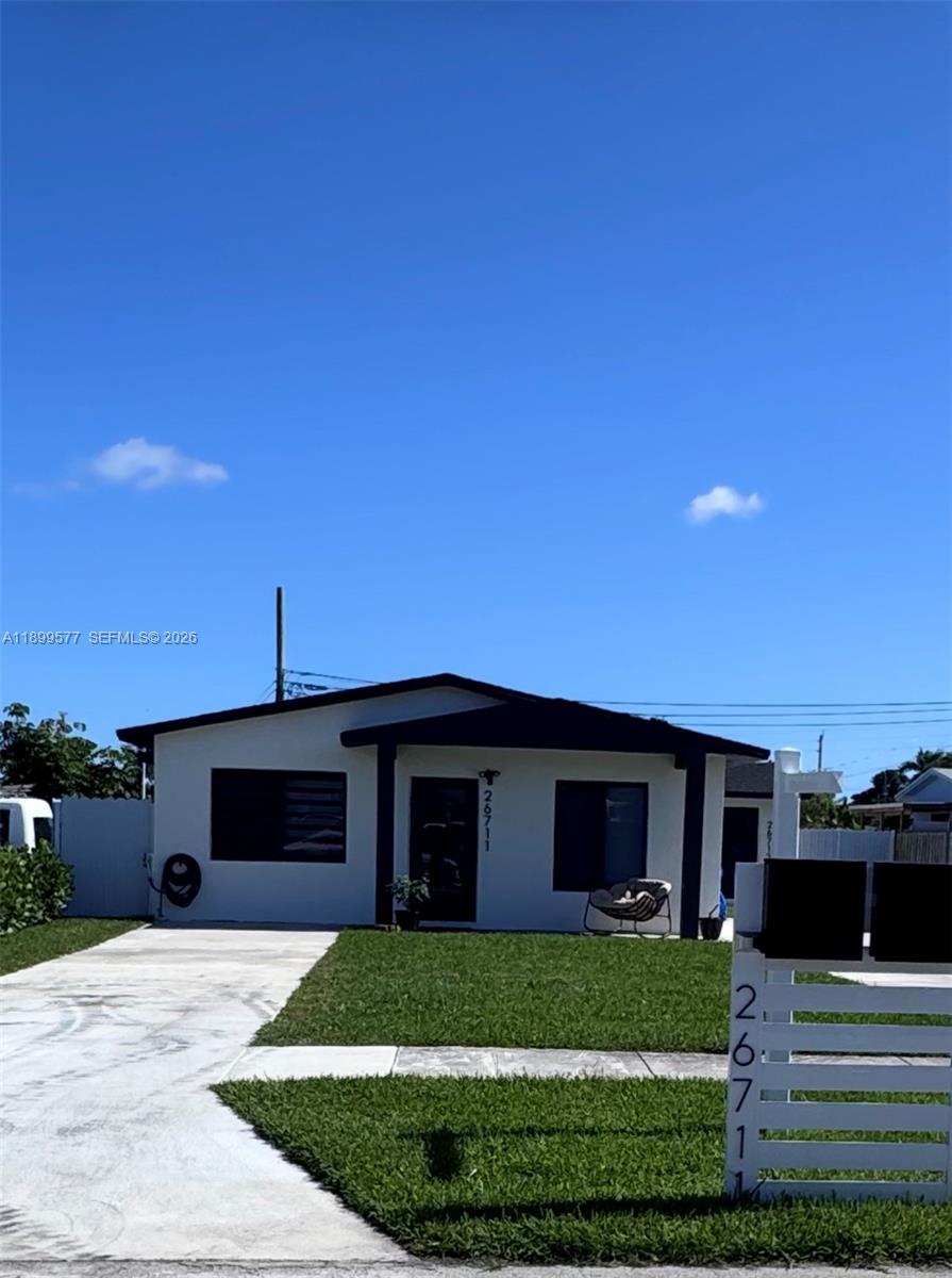 26711 Southwest 145th Avenue Road Homestead, FL 33032 - Photo 2 of 21 a front view of a house with a garden and yard