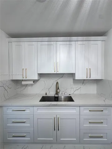 a kitchen with white cabinets and white appliances