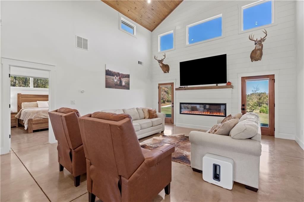 196 Frank Brown Road Maysville, GA 30558 - Photo 39 of 66 a living room with furniture a flat screen tv and a fireplace