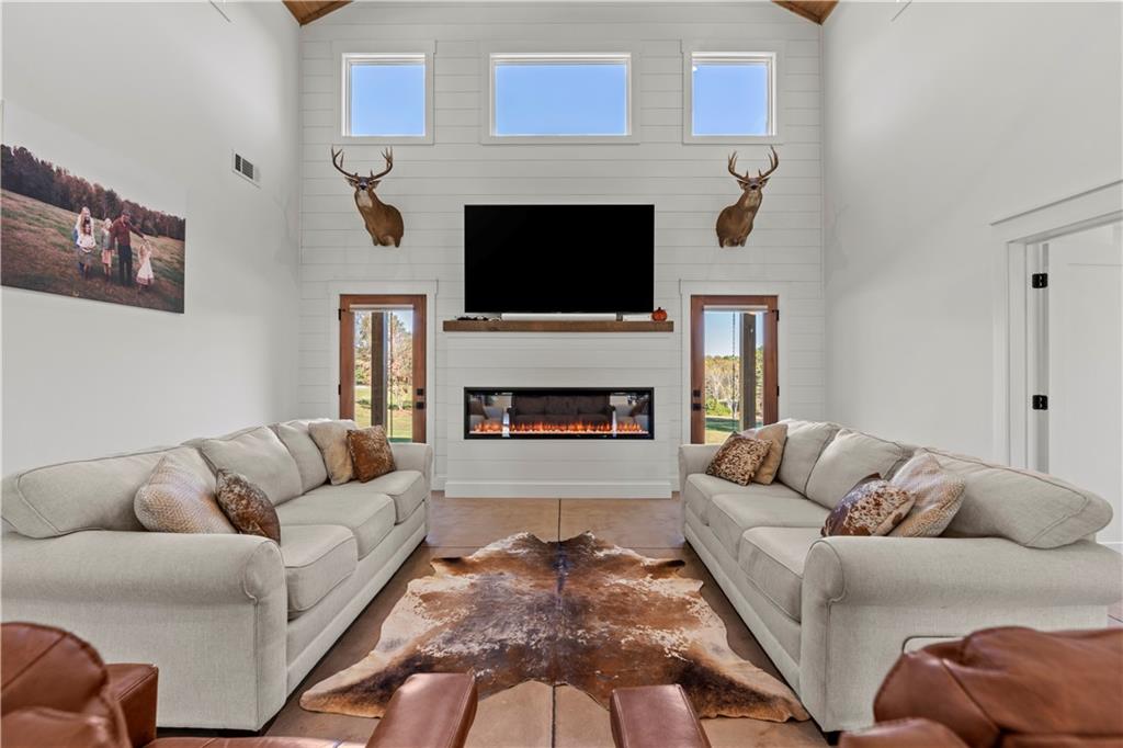 196 Frank Brown Road Maysville, GA 30558 - Photo 43 of 66 a living room with furniture a flat screen tv and a fireplace