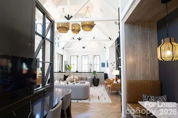 a living room with furniture kitchen view and a large window