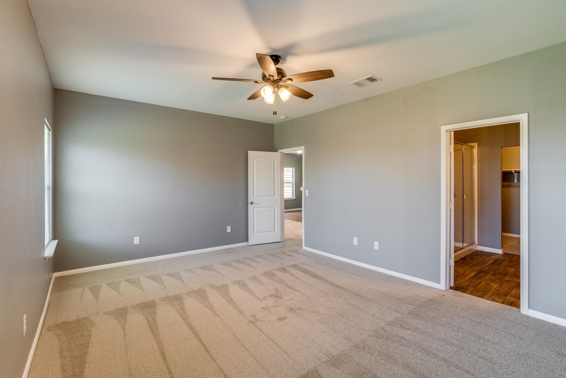 15128 Shell Bark Cove Austin, TX 78724 - Photo 10 of 25 An inviting bedroom offers neutral tones, soft carpeting, and convenient access to an adjacent primary bath.