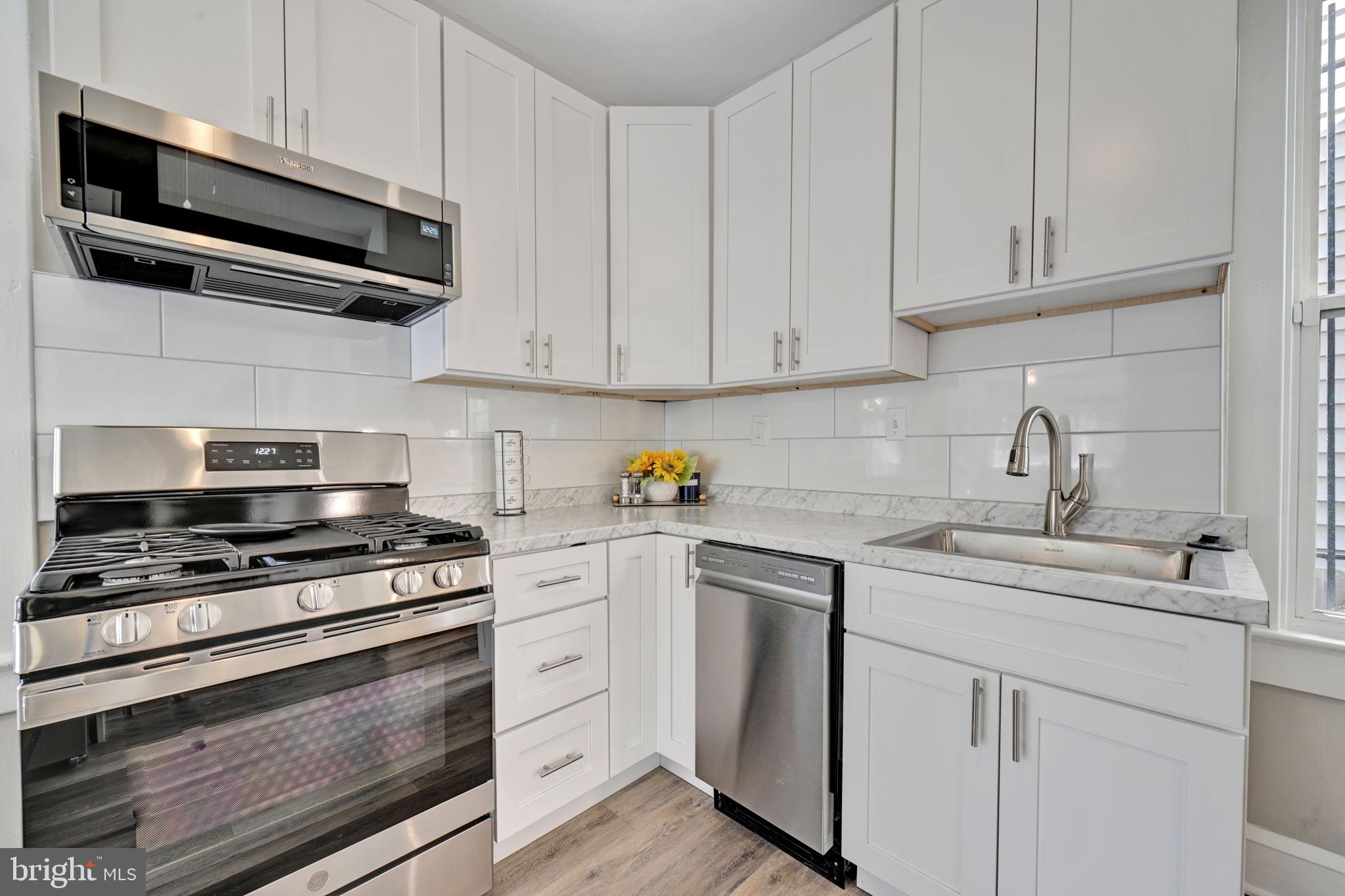 3005 7th Street Southeast Washington, DC 20032 - Photo 20 of 56 a kitchen with white cabinets and appliances