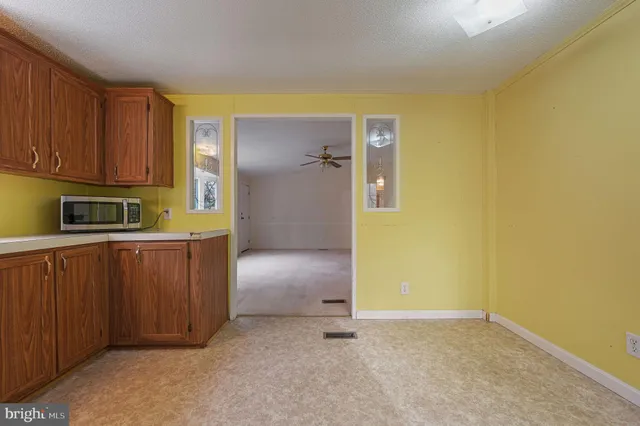 a view of a kitchen with wooden cabinets