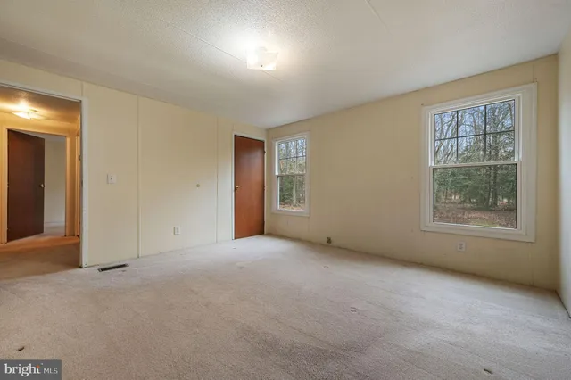 an empty room with windows and closet
