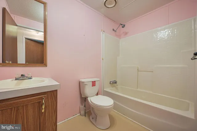 a bathroom with a toilet sink vanity tub and shower