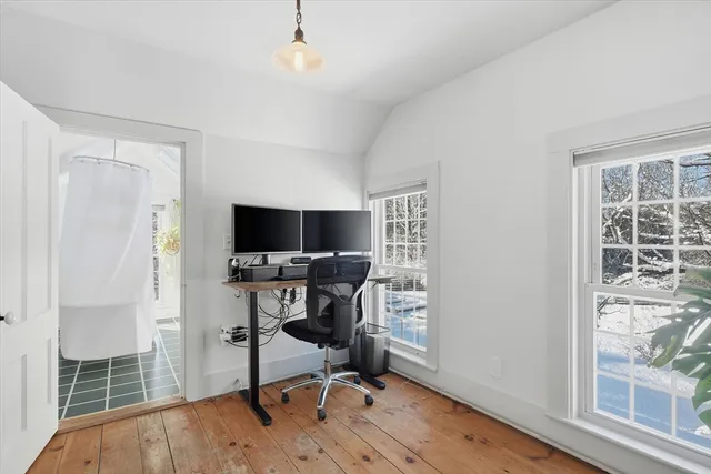 a view of a workspace with furniture and a window