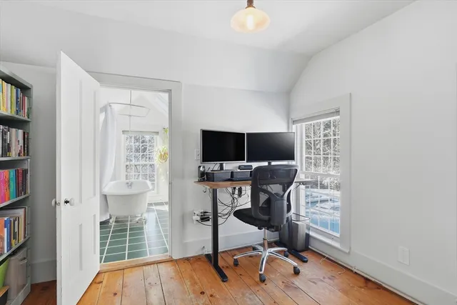 a view of a workspace with furniture and a window