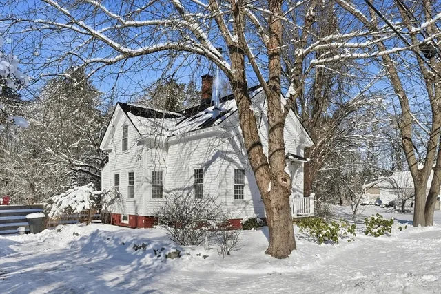 a front view of a house with a yard covered with snow