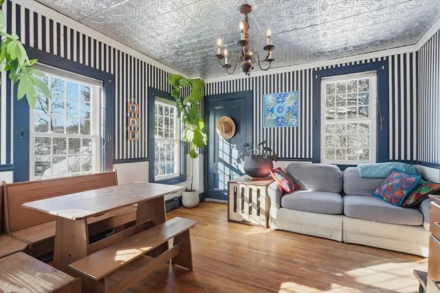 a living room with furniture a chandelier and a dining table