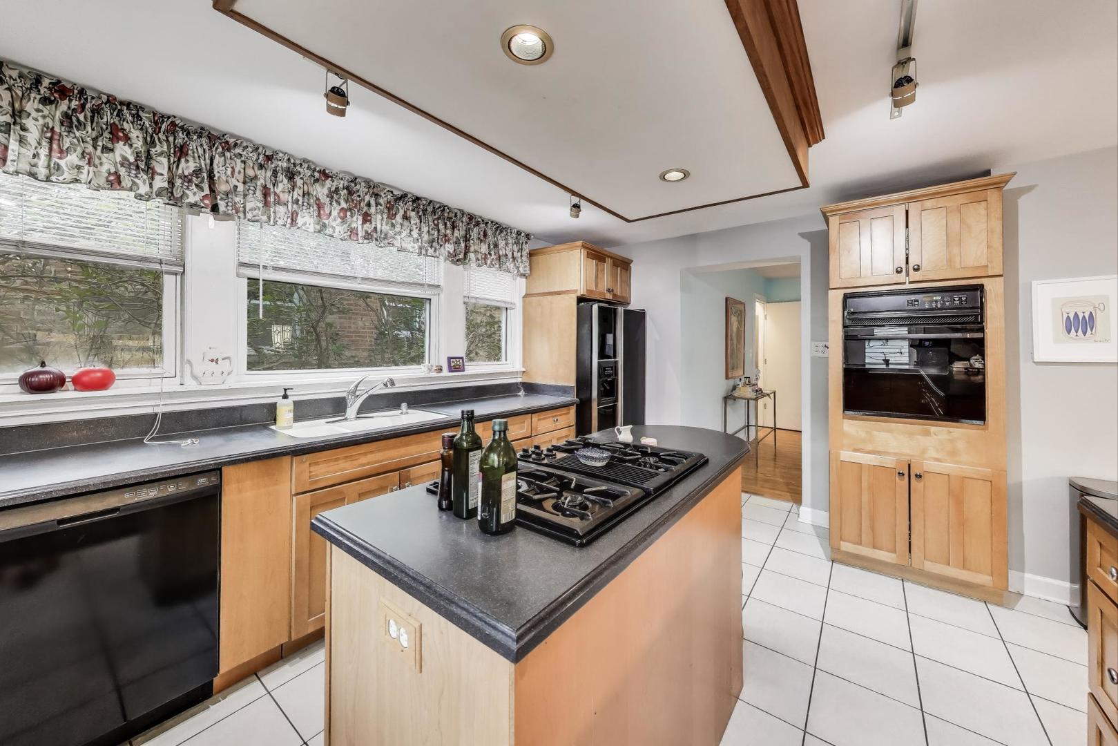 7401 West Main Street Niles, IL 60714 - Photo 14 of 37 a kitchen with stainless steel appliances granite countertop a sink and a stove