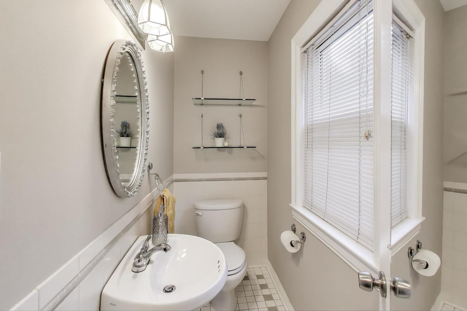 7401 West Main Street Niles, IL 60714 - Photo 15 of 37 a bathroom with a toilet a sink and a mirror