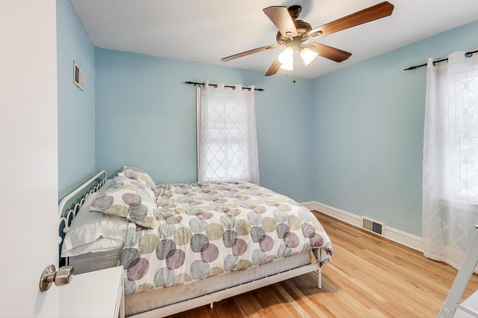 7401 West Main Street Niles, IL 60714 - Photo 18 of 37 a bedroom with a bed and a chandelier