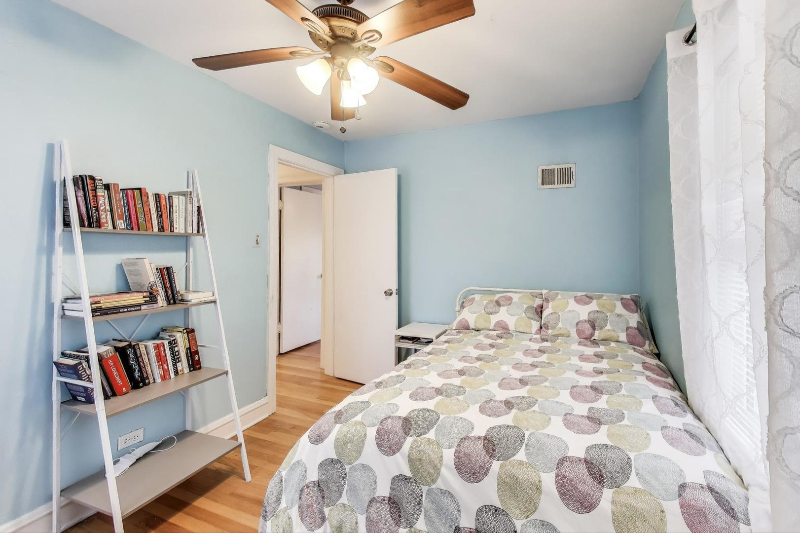 7401 West Main Street Niles, IL 60714 - Photo 19 of 37 a bedroom with a bed and a book shelf