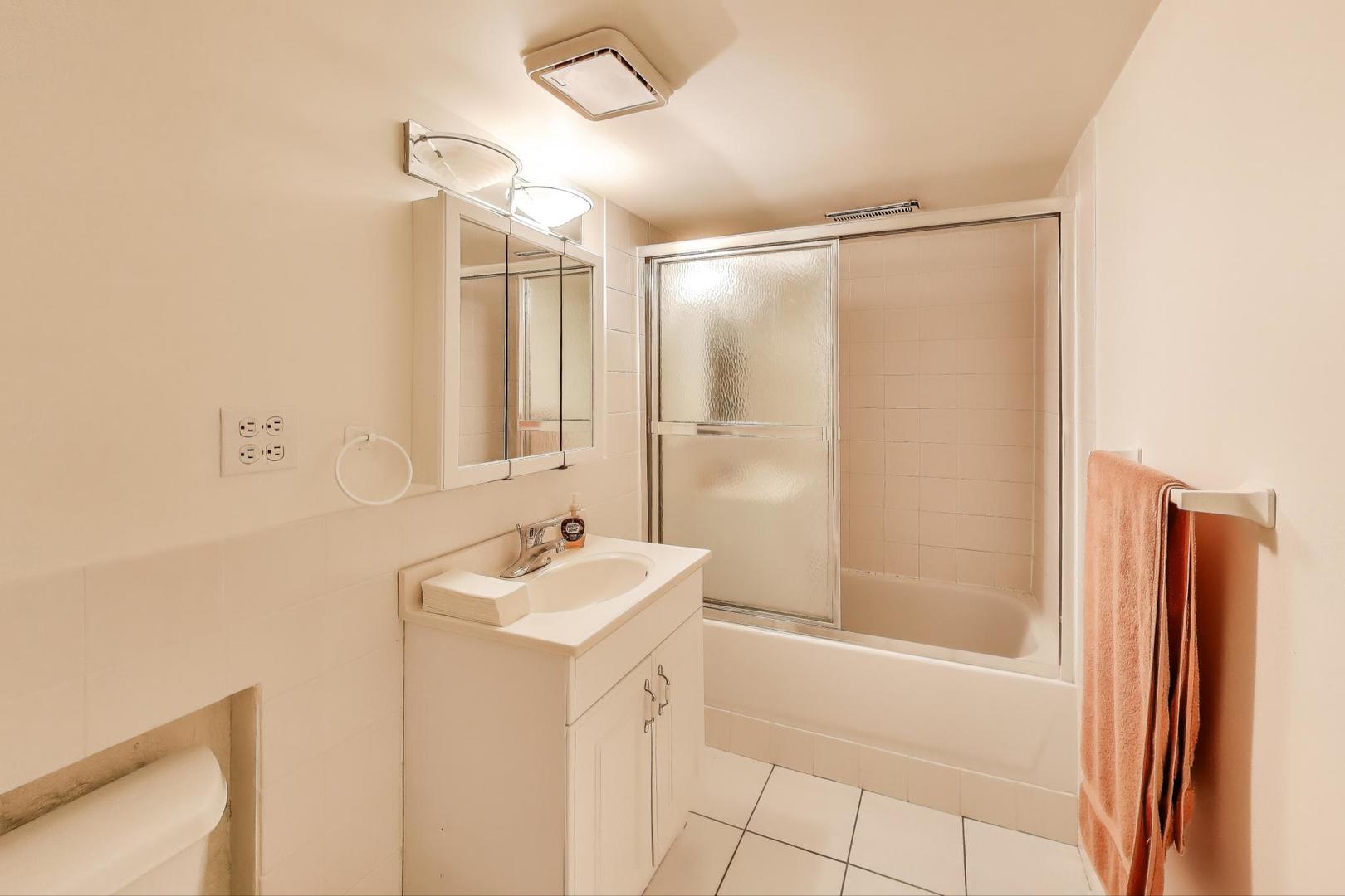 7401 West Main Street Niles, IL 60714 - Photo 28 of 37 a bathroom with a sink a mirror and a shower