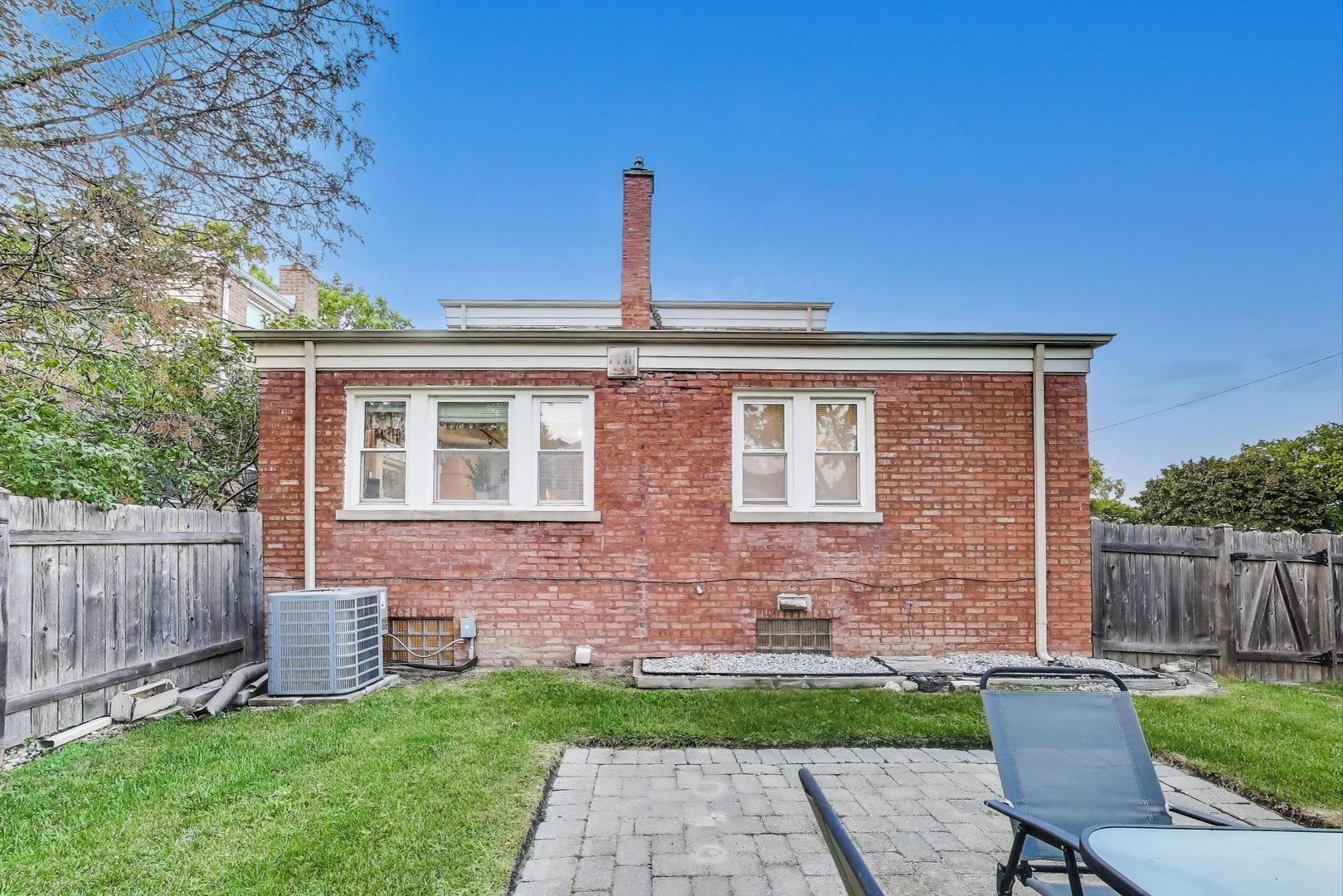 7401 West Main Street Niles, IL 60714 - Photo 31 of 37 a front view of a house with a yard and outdoor seating