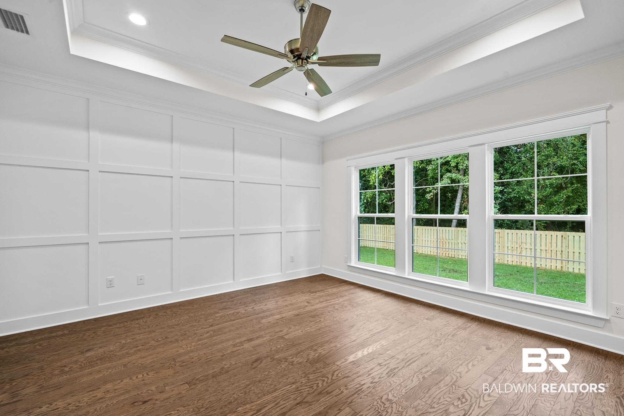 29 Signal Hill Road Daphne, AL 36527 - Photo 19 of 36 Spare room with ceiling fan, a raised ceiling, dark hardwood / wood-style flooring, and ornamental molding
