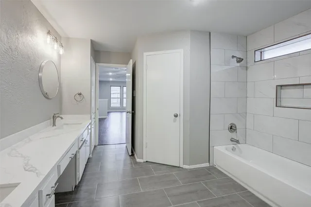 a bathroom with a tub sink and mirror